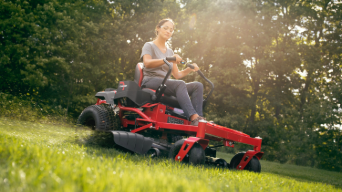 woman on a zero-turn lawn mower